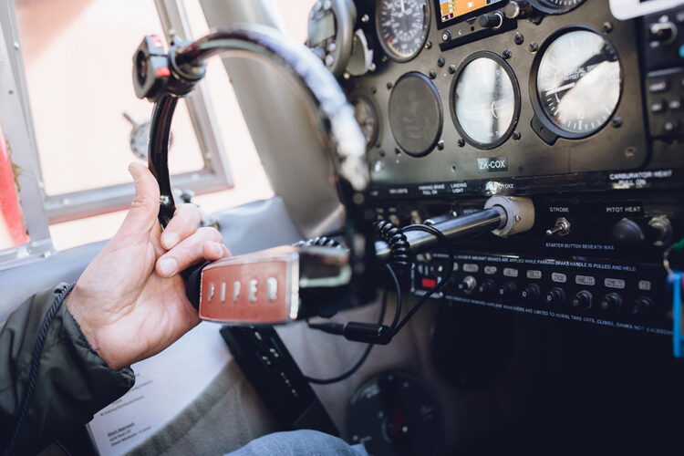 Hand on steering wheel of small plane